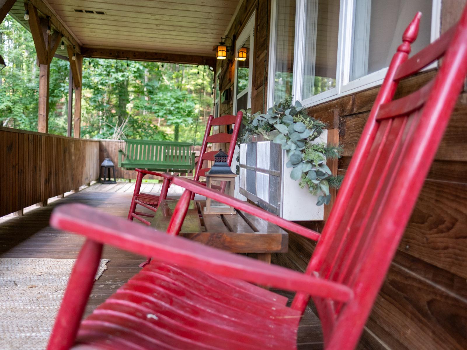 Red rocking chairs on the covered front porch of Cabin #1
