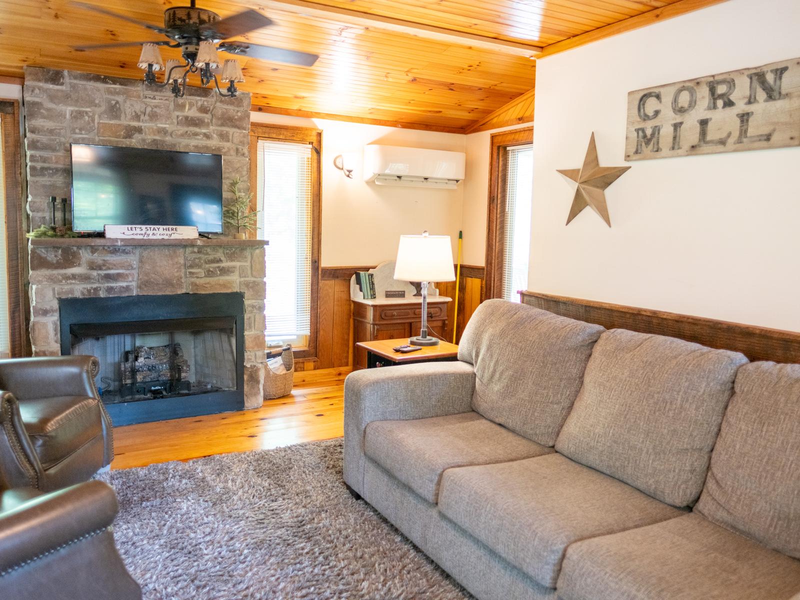 Cabin #2 living room with a stone fireplace and pine ceiling